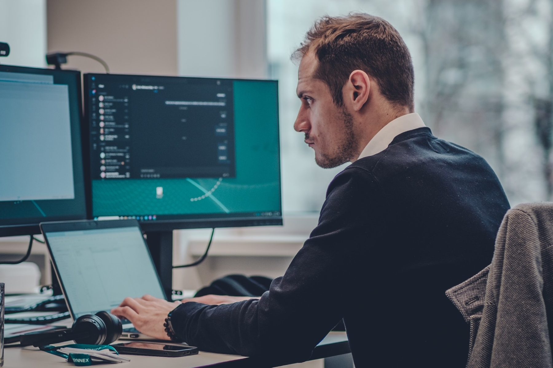 Mann arbeitet konzentriert an zwei Bildschirmen, Employer Branding