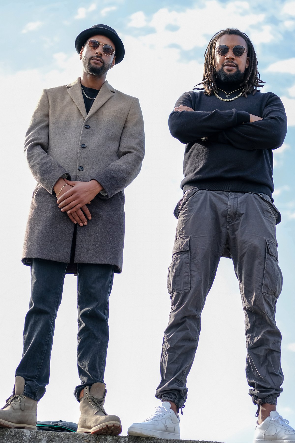 Zwei Männer in Streetstyle-Outfits vor blauem Himmel
